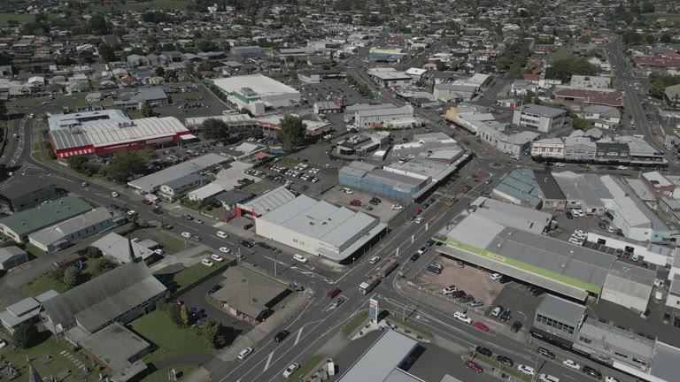 An aerial view of streets and intersections, with cars moving between shops and car parks.